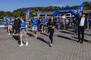 Fala startowa mknie w stronę mety; na pierwszy plan wysuwa się kobieta z numerem 113.