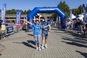 Biegaczka z numerem 648 z rozłożonymi ramionami i partner z numerem 647 stoją tuż za bramą mety.