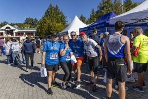 Czworo uczestników z medalami i numerami 281, 338, 352 i 490 pozuje przy namiocie Parlamentu Europejskiego.